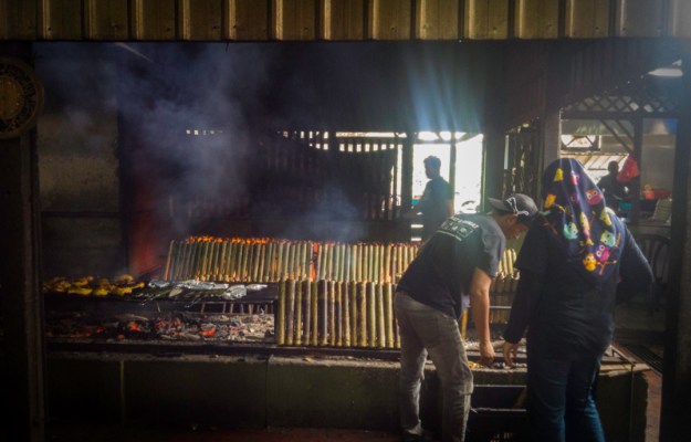 Bambu-bambu berisi lemang tengah dibakar