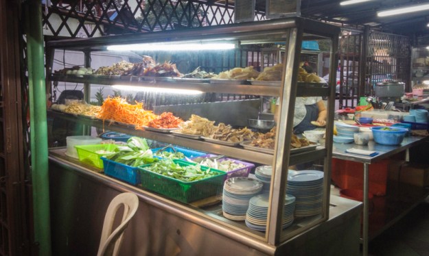 Etalase berisi lauk-pauk untuk nasi bubur Kah Mah Tomyam